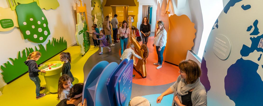 In einem bunt gestalteten Ausstellungsraum probieren Kinder und Erwachsene verschiedene Mitmachstationen aus.