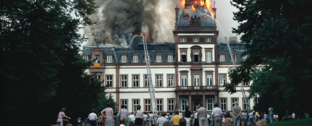 Schaulustige stehen vor dem brennenden Schloss Philippsruhe 1984 in Hanau.