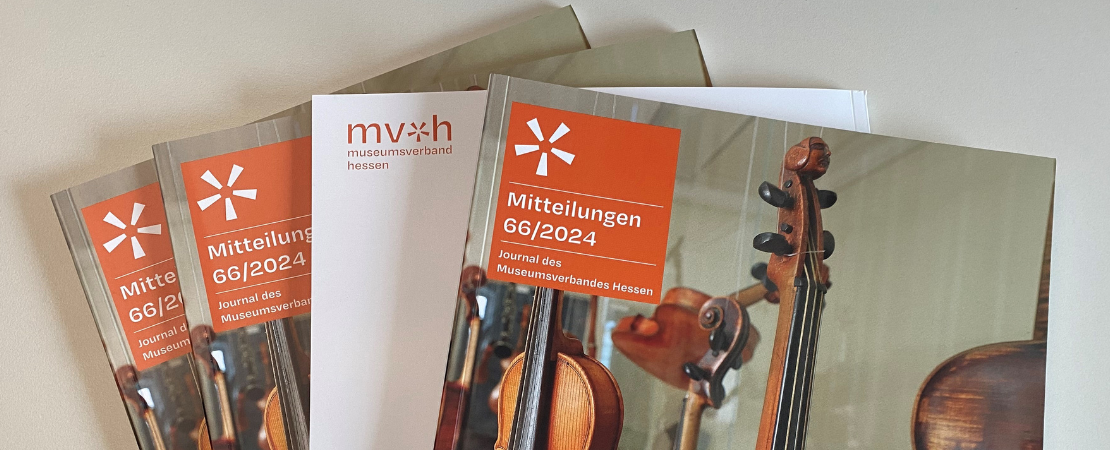 Vier aufgefächert liegende Ausgaben der Mitteilungen Heft 66/2024 - Journal des Museumsverbandes Hessen, Auf dem Titelbild sind Streichinstrumente aus dem Spohr Museum in Kassel.