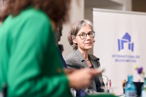 Carmela Thiele schaut in Richtung von Moderatorin Amira El Al bei der Podiumsdiskussion.