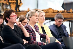 Birgit Kümmel und Christina Reinsch verfolgen die Podiumsdiskussion.