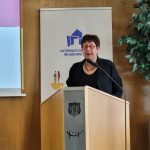 Vorsitzende Dr. Birgit Kümmel steht hinter einem Stehpult. Im Hintergrund ist das Banner zum Internationalen Museumstag zu sehen, daneben eine große Topfpflanze.