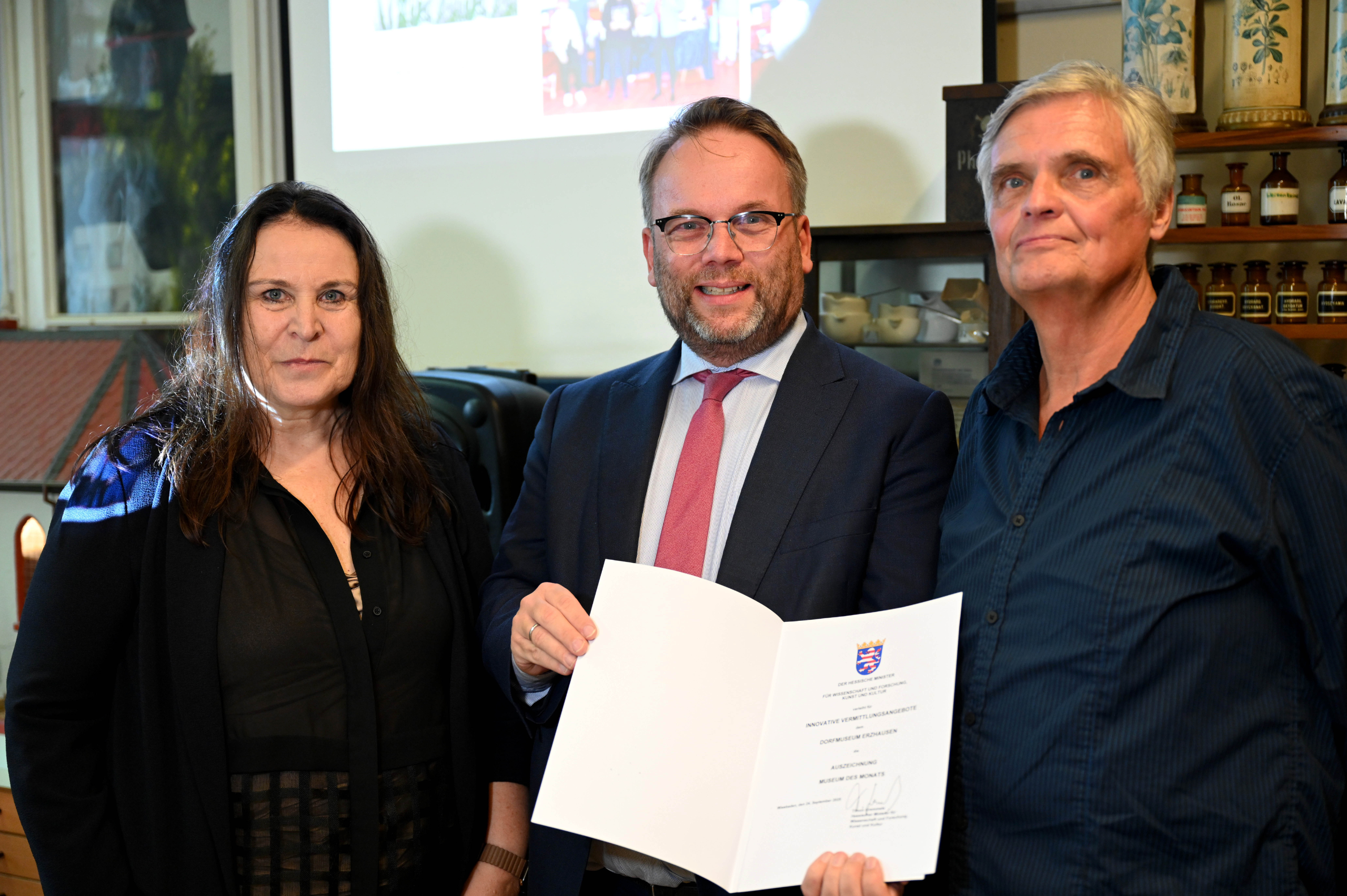 Urkundenübergabe: Kunst- und Kulturminister Timon Gremmels (Mitte) überreicht Christina Seibold und Jörg Dohn vom Ortskundlichen Arbeitskreis Erzhausen die Auszeichnung „Museum des Monats