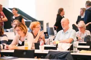 Eine Gruppe von Personen die sich sitzend unterhalten.