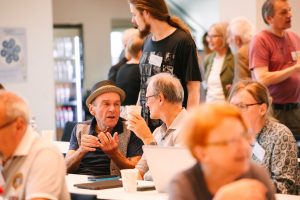 Eine Gruppe von Personen die sich sitzend unterhalten.