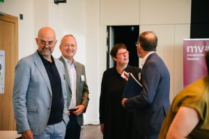 Vorstandsmitglieder des Museumsverbandes Hessen stehen zusammen und lächeln. Zwei Personen sind einander zugewandt im Gespräch.
