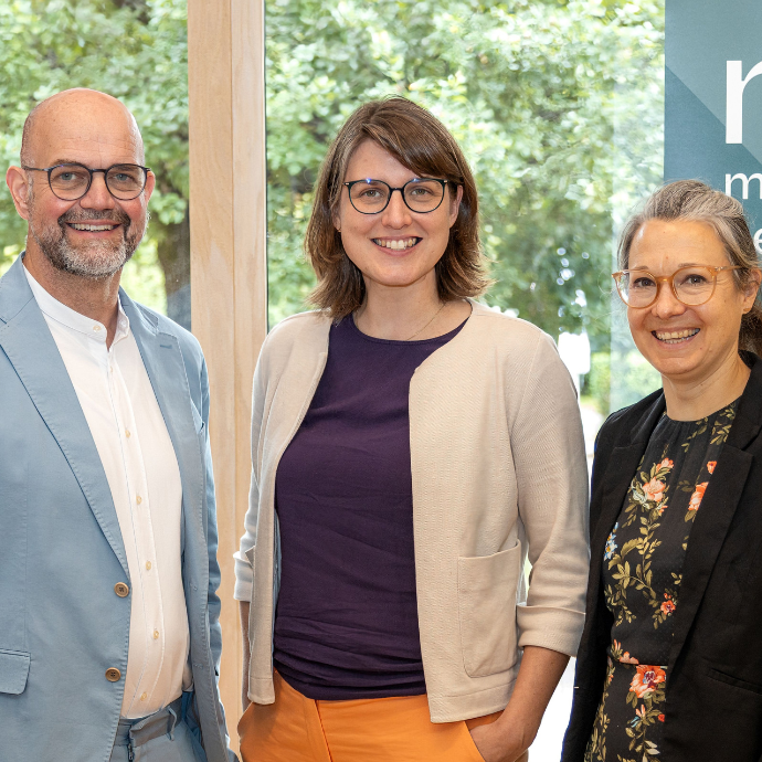 Dirk Pörschmann, Katharina Weick-Joch und Ulrike Sbresny stehen nebeneinander vor einem Fenster und einem Banner des Museumsverbands Hessen und blicken in die Kamera.